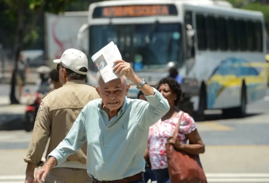 Homem se protege do sol em dia quente no Rio de Janeiro (Foto: Agência Brasil)